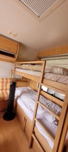2 łóżka piętrowe w pokoju z sufitem w obiekcie Nikita caravane w mieście Aywaille