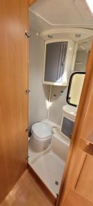 een kleine badkamer met een toilet en een televisie bij Nikita caravane in Aywaille