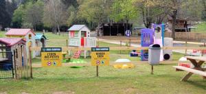 a playground with different types of play equipment and signs at Nikita caravane in Aywaille