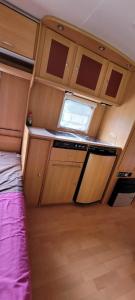 una pequeña cocina con ventana en una pequeña habitación en Nikita caravane en Aywaille