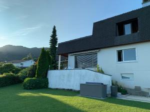 ein weißes Haus mit einem Zaun im Hof in der Unterkunft Retreat Lodge Schürmatt -Leben wie SchweizerInnen in Günsberg  