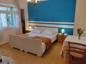 een slaapkamer met een groot bed en een blauwe muur bij Apartments Milka in Vodice