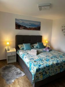 a bedroom with a bed with a blue comforter at Villa Lella in Rukavac