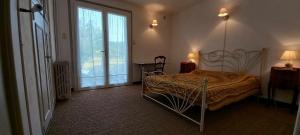 um quarto com uma cama e uma grande janela em Gîte près de Sarlat avec jardin et salon de massages em Carsac-Aillac