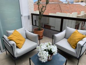 un patio con 2 sofás y una mesa con flores en Luxury Atlantic Studio Puerto de la Cruz en Puerto de la Cruz