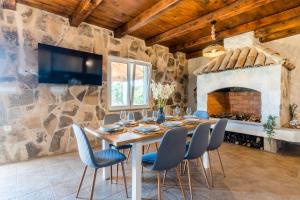 a dining room with a table and chairs and a stone wall at Villa Storia in Velika Čista