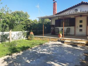 a house with a driveway in front of it at Tota's guest house, 4 min walk to the beach in Levendokhórion