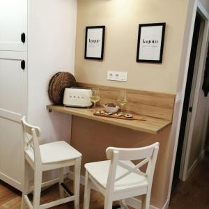 a kitchen with two chairs and a counter with wine glasses at Rías Baixas. Acogedor piso en la Ría de Arousa in Ribeira