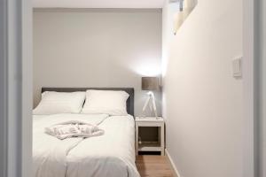 een witte slaapkamer met een wit bed en een tafel bij Summer House in Zandvoort