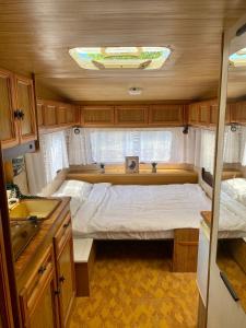 a small bedroom in an rv with a bed at Beachfront Caravans - Meadow Camp in Chernomorets