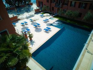 una vista aérea de una piscina con sillas y sombrillas en Hotel Bogliaco, en Gargnano