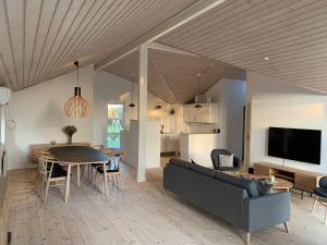 Moderne sommerhus, 8 senge, 250 mtr til sandstrand في سالغيليز: غرفة معيشة مع أريكة وطاولة