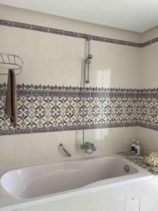 uma banheira branca numa casa de banho em azulejo em Villa avec piscine privée em Tabarca