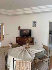 ein Esszimmer mit einem Tisch und einem TV in der Unterkunft Villa avec piscine privée in Tabarca