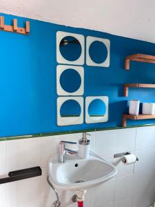 a bathroom with a sink and a blue wall at Loft buhardilla en perfecta ubicación in Santander