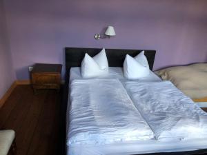 1 dormitorio con 1 cama con sábanas y almohadas blancas en Landbahnhof Buschhof 1 Stock 