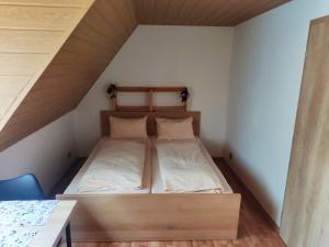 uma cama num pequeno quarto com uma mesa em Penzion Leštiny em Dolný Kubín
