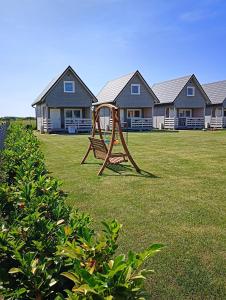 a playground in front of a row of houses at Domki Weekend in Rusinowo