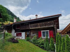 a log house with red doors and a yard at Chesa Prema Bed & Breakfast - Restaurant in Disentis