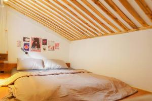 1 dormitorio con 1 cama con techo de madera en Loft in central Ben Thanh-2 beds en Ho Chi Minh