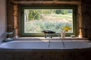 bañera en una habitación con ventana en ENJOY Cozy Romance Hills Forest Gardens Views Sauna Whirlpool Bath en Jablonné v Podještědí