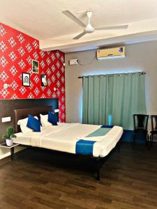 a bedroom with a large bed with blue and red walls at Udupi Comforts in Udupi