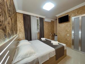 a bedroom with a large bed and a television at Opera Avenue Hotel in Yerevan