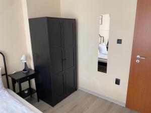 a bedroom with a black cabinet next to a bed at Къща за гости Германови in Obzor +105 photos