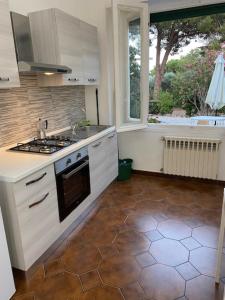 a kitchen with a stove and a sink and a window at Isola d'Elba casa vacanze - Villa Portello - la casina bis - quarzo-pirite in Rio Marina