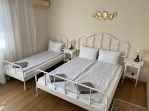 a bedroom with two beds and two night stands at Къща за гости Германови in Obzor