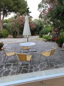 una mesa y sillas con una mesa y una sombrilla en Isola d'Elba casa vacanze - Villa Portello - la casina bis - quarzo-pirite, en Rio Marina