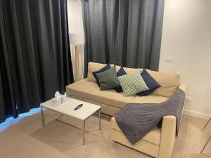 sala de estar con sofá y mesa en Mulberry 2BR-2BA Rooftop Pool, BBQ, WiFi & Netflix - Central Location en Canberra