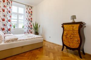 a bedroom with a bed and a dresser and a window at OK LUX Apartments in Krakow