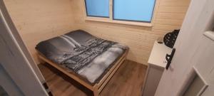 a small bed in a room with a window at Wakacyjny dom in Karwia