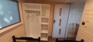 a room with a closet with a door and a chair at Wakacyjny dom in Karwia