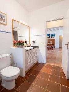 a bathroom with a toilet and a sink and a mirror at Casa Piedra in Cala Saona