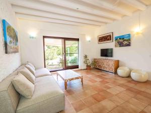 a living room with a couch and a tv at Casa Piedra in Cala Saona