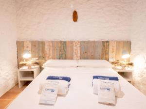 1 dormitorio con 1 cama con toallas en Casa Piedra, en Cala Saona