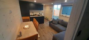 a small living room with a couch and a table at Wakacyjny dom in Karwia