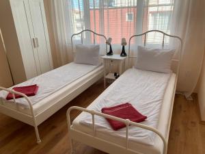 two twin beds in a room with a window at Къща за гости Германови in Obzor