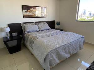 um quarto com uma cama grande, uma mesa de cabeceira e uma janela em Katara On Smith - 2 Bed 2 Bath CBD Appartment em Darwin