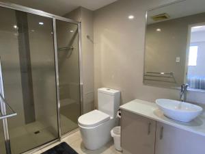 a bathroom with a toilet and a sink and a shower at Katara On Smith - 2 Bed 2 Bath CBD Appartment in Darwin