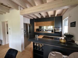 a kitchen with a black counter top and wooden ceilings at Chiemgau Ferienhaus Premium by BellaVita in Bad Endorf