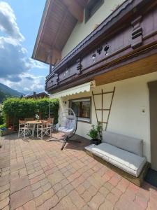 a patio of a house with a couch and a table at 9 persons apartment Haus Jens in Niedernsill