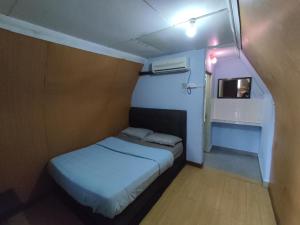 a small room with a bed and a small window at Mgh Marang guest house in Kampong Kijing