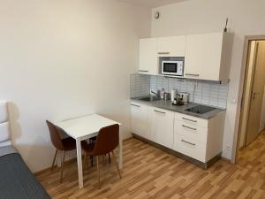 eine kleine Küche mit einem Tisch und einer Mikrowelle in der Unterkunft Apartment 153 - Rezidence Eliska - Prague 9 in Prag