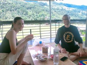 a man and a woman sitting at a table at Hoa Sơn Tra Hotel in Mù Cang Chải