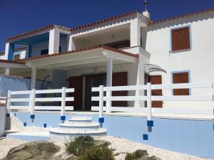 una casa blanca con una valla delante en Villa la Torre Libeccio en Torre Dei Corsari