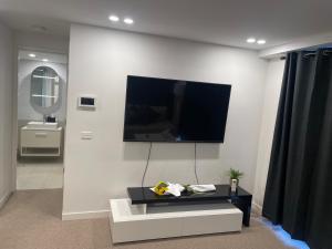 a living room with a flat screen tv on a wall at Mulberry 2BR-2BA Rooftop Pool, BBQ, WiFi & Netflix - Central Location in Canberra