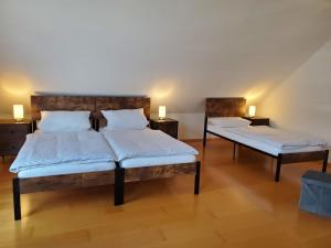 two beds in a room with two lamps on tables at Ferienwohnung Fröse in Altenbeken